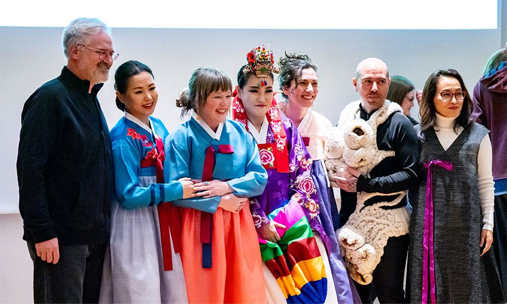 Seven people pose for a photo at the wearable runway show.