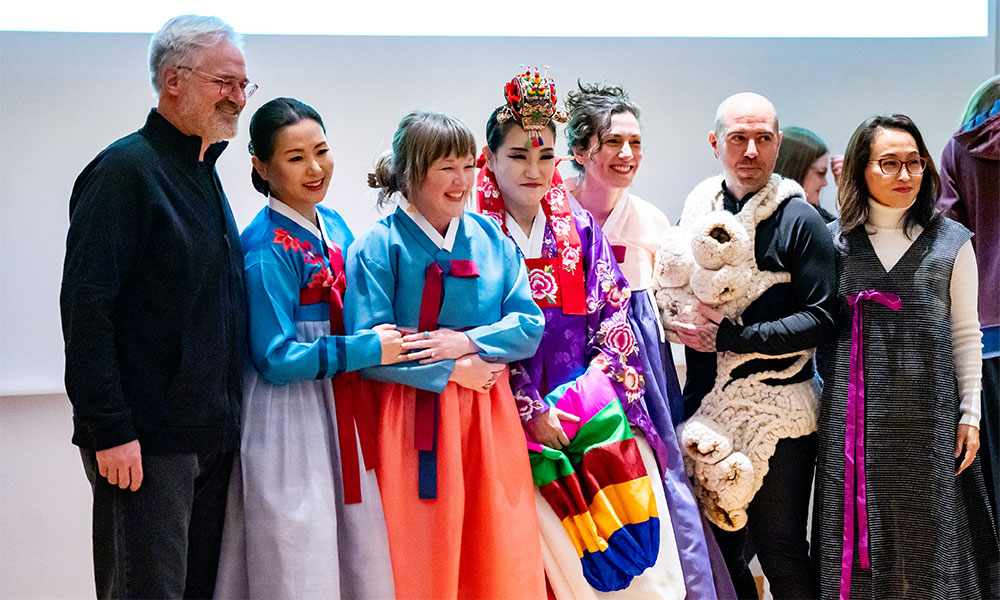 Seven people pose for a photo at the wearable runway show.