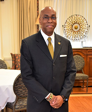 A portrait of Malcolm Taylor wearing a nice suit.