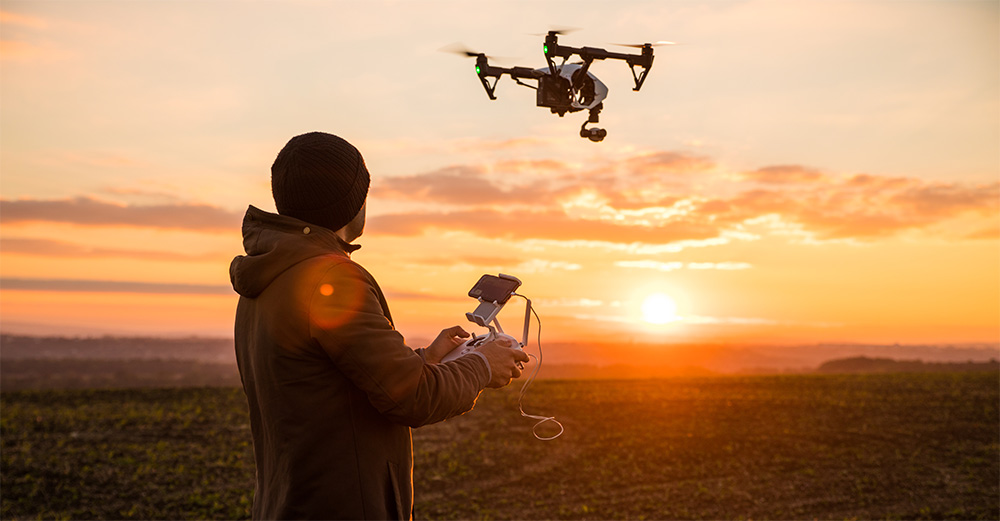 A person flies a drone over a field.