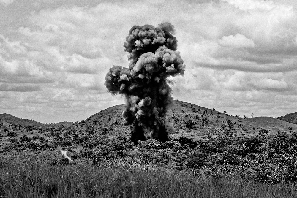 An explosion and cloud of smoke emerging out of the jungle.