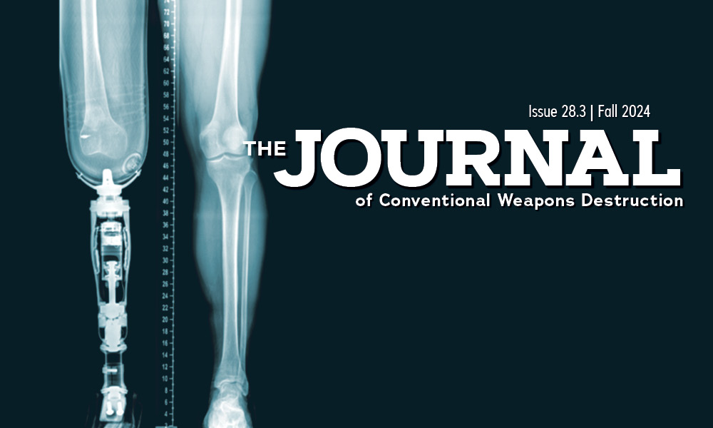 An x-ray of a person's legs, the left leg has been amputated above the knee and prosthetic is attached; text reads "The Journal of Conventional Weapons Destruction"