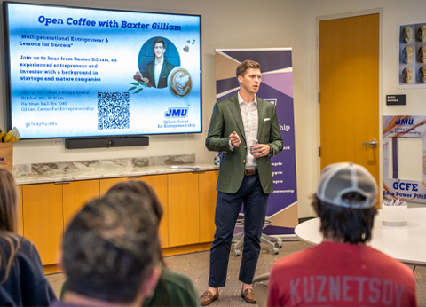 Baxter Gilliam speaking at an event titled "Open Coffee with Baxter Gilliam," focusing on entrepreneurship and success lessons, with a presentation displayed behind him.