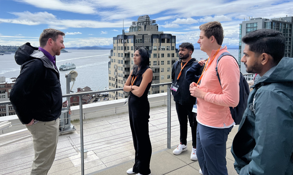 Students talking while standing on a rooftop over looking Elliott Bay