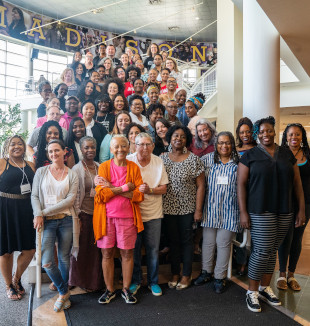 A large group photo on the winding steps in a large building.