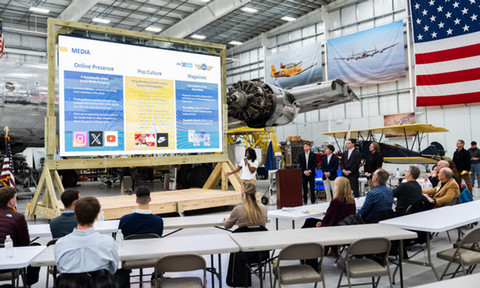 A class of students working in an airplane hangar.