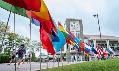 Students walk by flags from all different countries