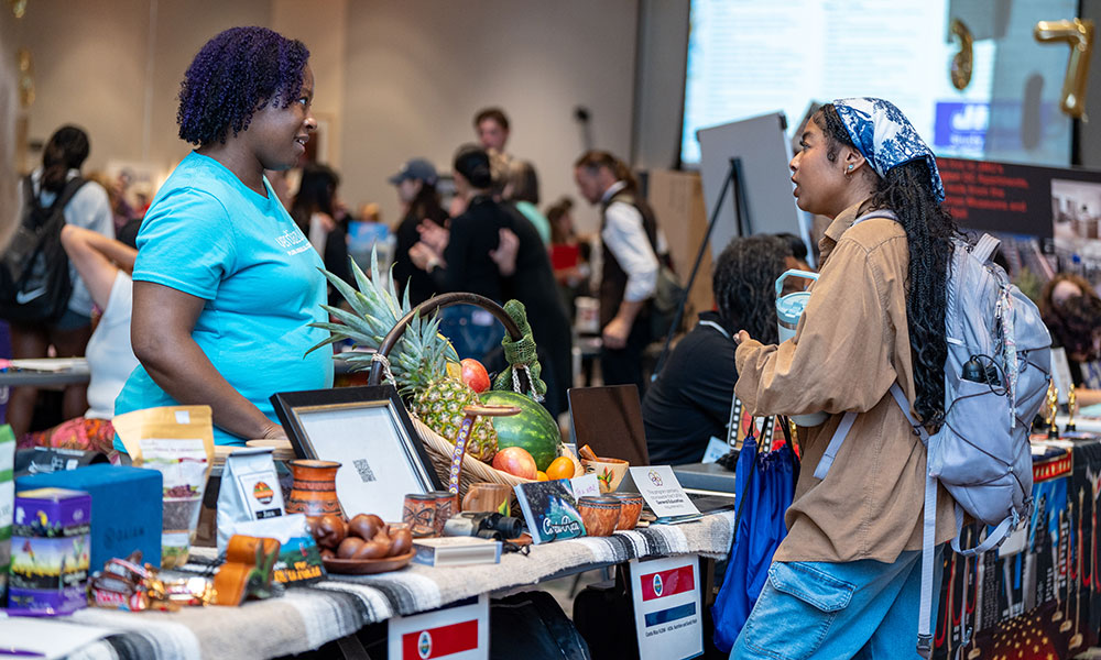 Two women speak at a display table