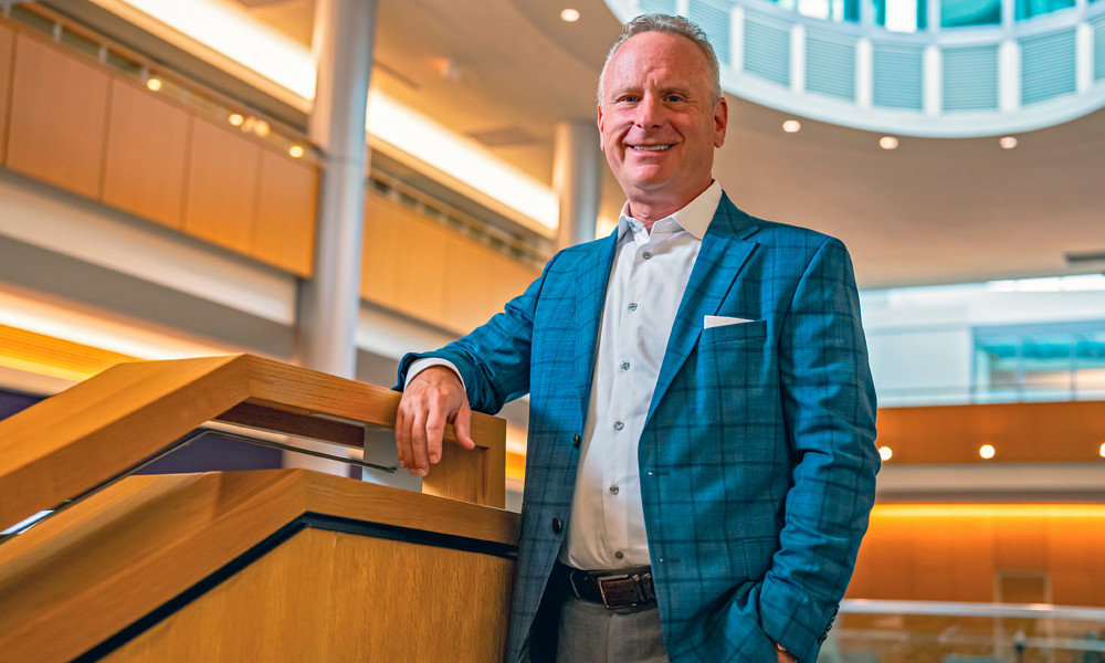 Rick Kushel ('87) stands on the grand staircase is Hartman Hall