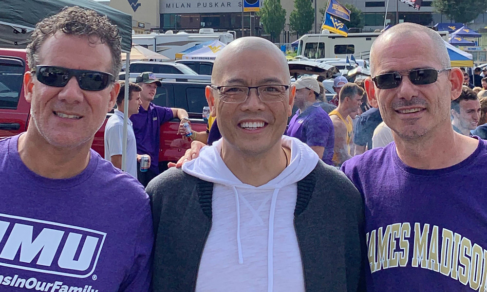 JMU roommates and longtime friends David Hinkle (’92), Tan Nguyen (’92) and Darren Brubaker (’92) tailgate at a JMU vs. WVU football game in Morgantown, West Virginia. 