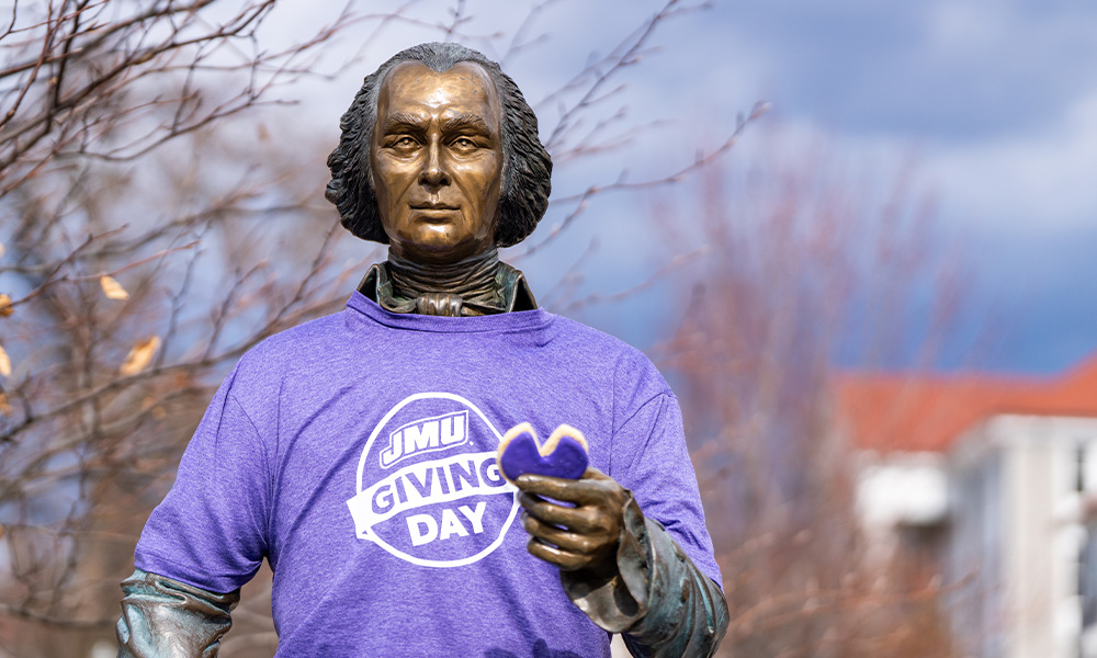 Statue of James Madison wears a purple shirt that reads "JMU give day."