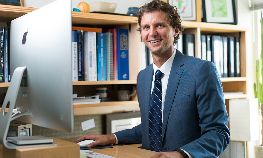 A portrait of Dr. Mark Gabriele,  a JMU Biology professor, at his desk in his office