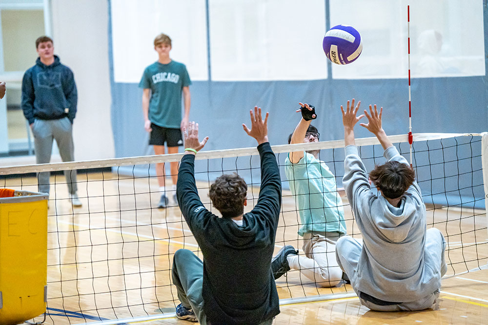 students playing sitting volleyball