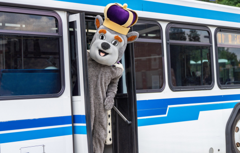 School mascot exiting a public transit bus