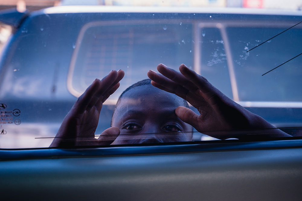 A photo of a child, peeking through a car window in Ghana.