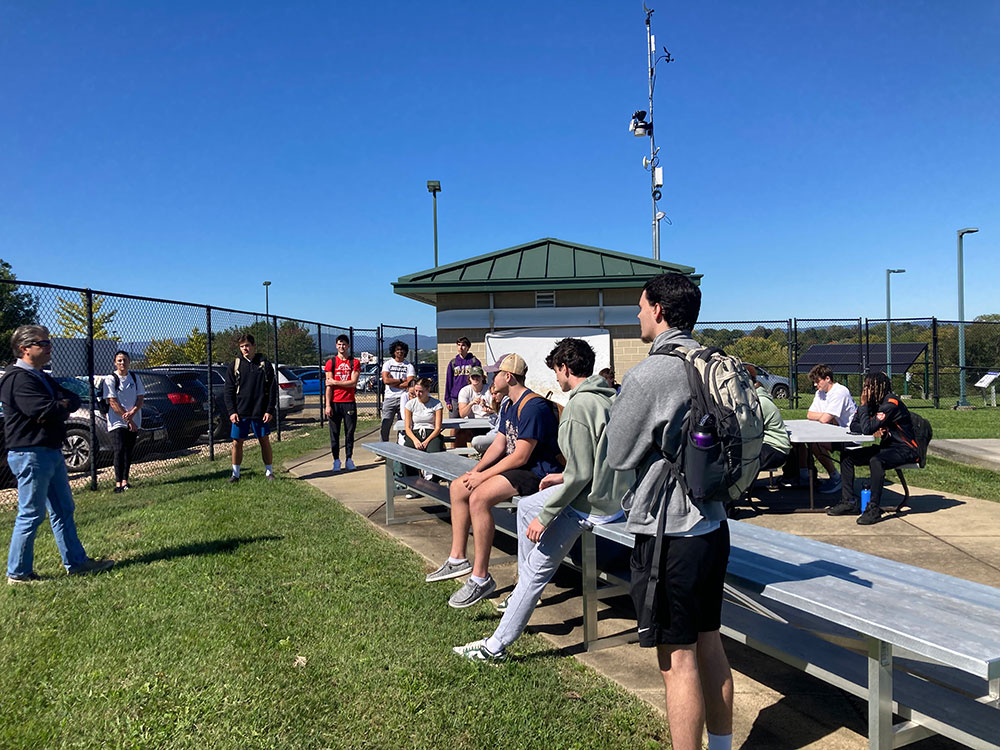 college students on bleachers at wind facility