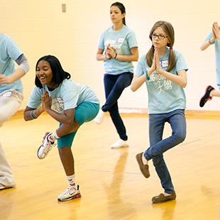 Young participants practice yoga at a Moovin' and Groovin' day event.