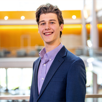 Headshot of Duncan Kelleher in a suit in Hartman Hall