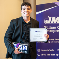 Student Jared Marcus stands with a certificate.