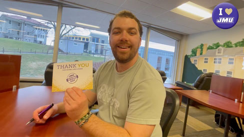 Student holding a Giving Day thank you card