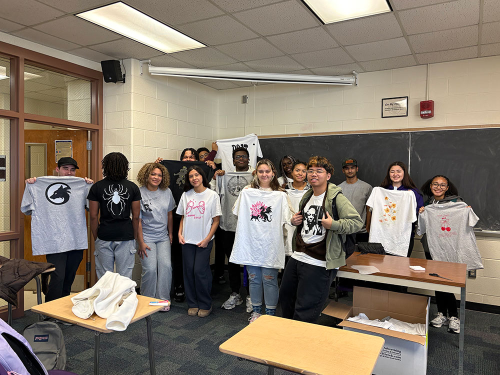 students holding up t-shirts