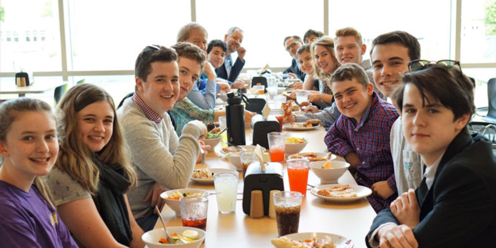 Piano day participants smiling at a dining table