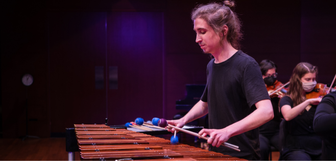 person playing 4-mallet marimba