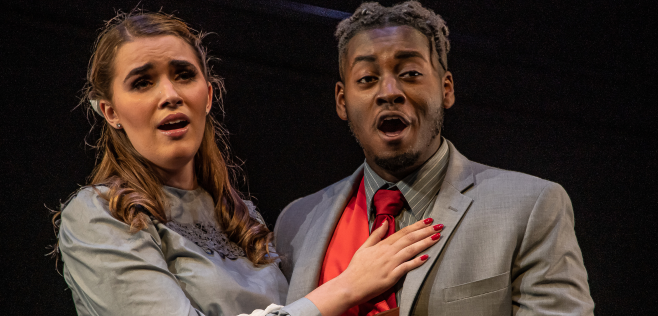 woman and man singing on stage