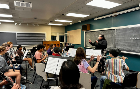 woman conducts rehearsal in a classroom