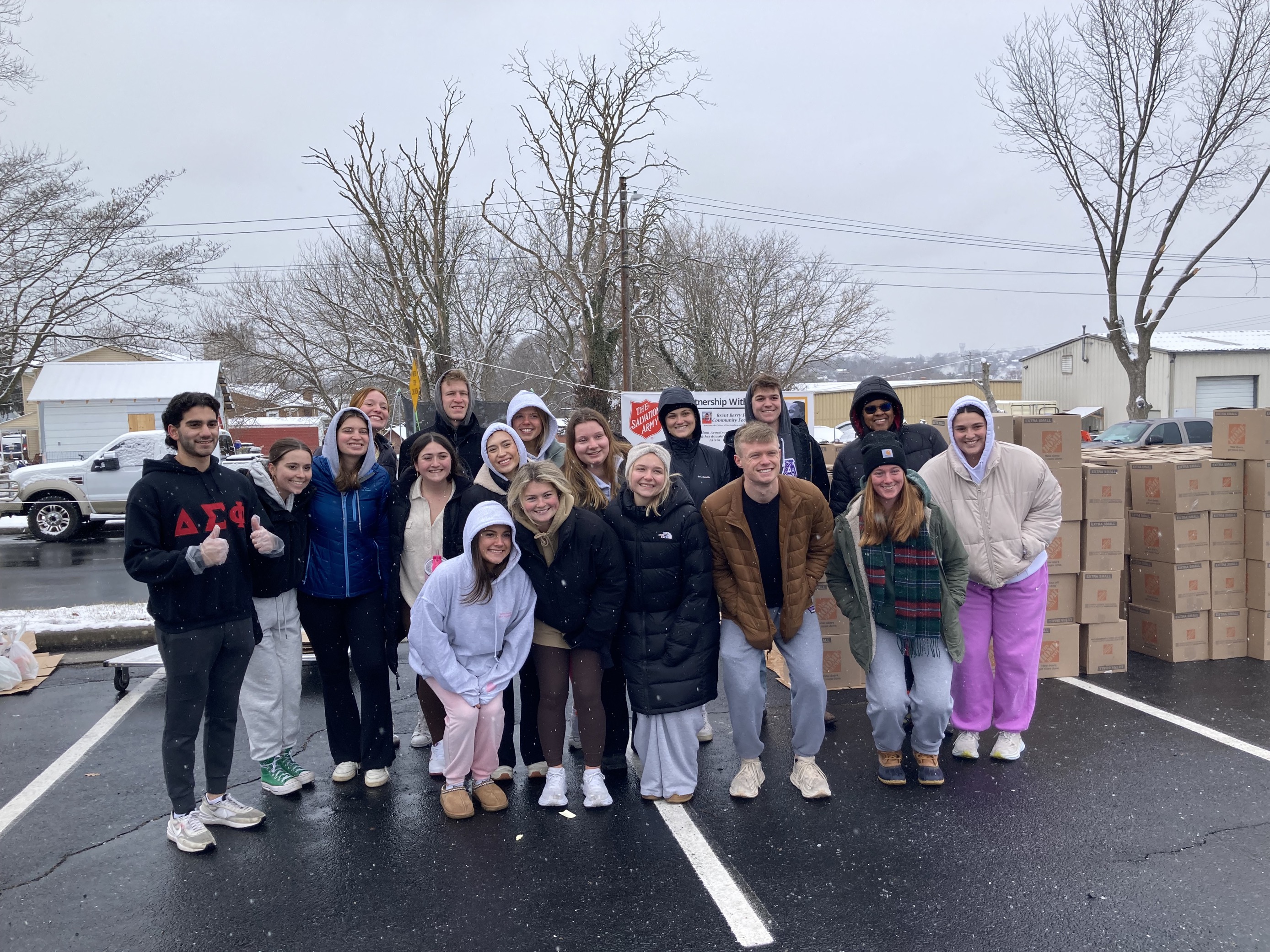 group of students in front of a pile of boxes donated to the Salvation Army