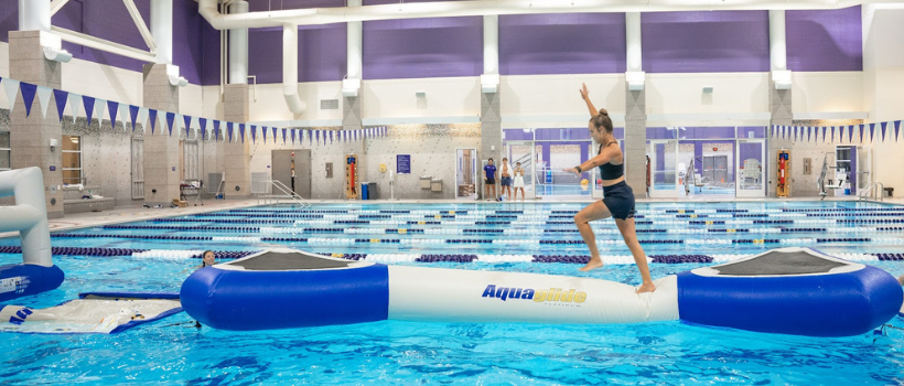 students walking on floating device in pool