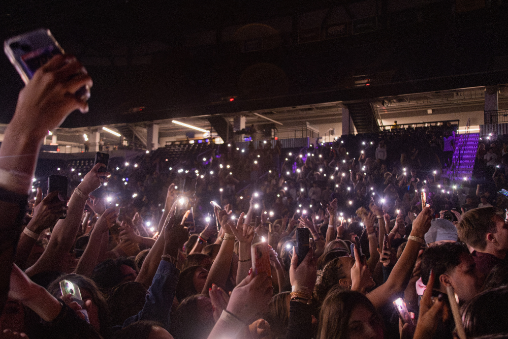 a view from the the audience at a concert holding their phones in the air