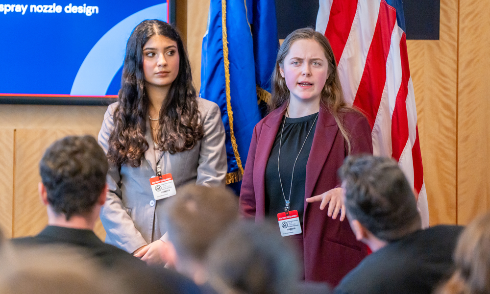Members of the Less Than Lethal group, Isabella Santo (left) and Bonnie Pohland, who are third-year Political Science and International Affairs majors, present their project in Washington, D.C., in December 2023.