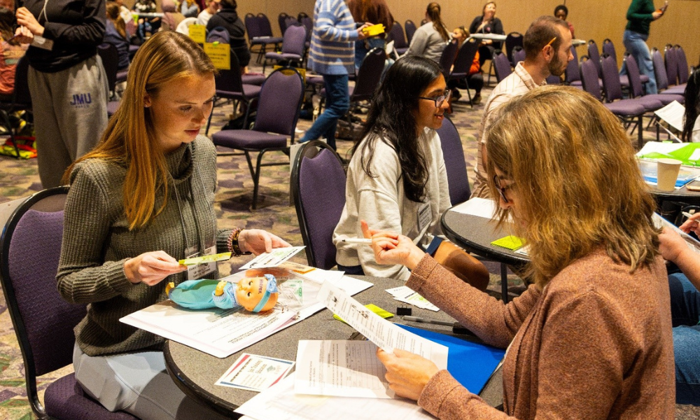 Students working through poverty simulation with help from volunteers