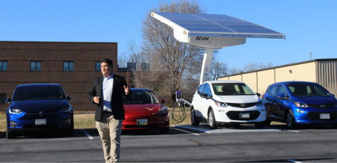 Man speaking in front of charging station