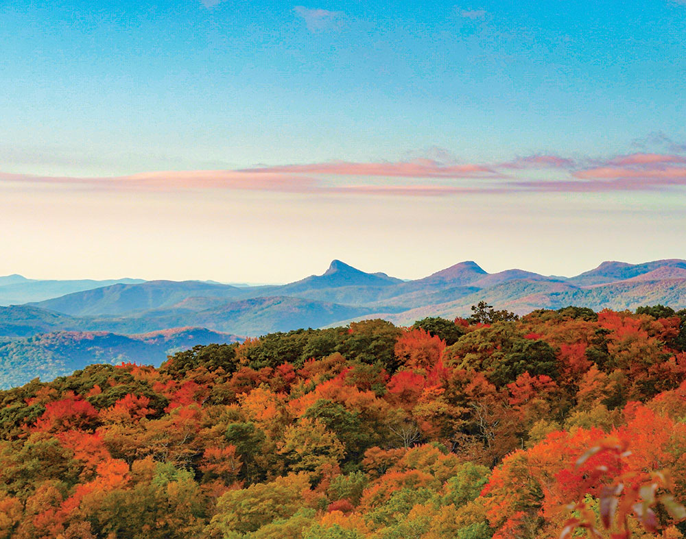 Exterior photo of the Blue Ridge mountains on a clear day, where the trees are starting to turn red and orange.