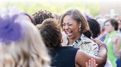 two women hugging in a crowd of women outdoors